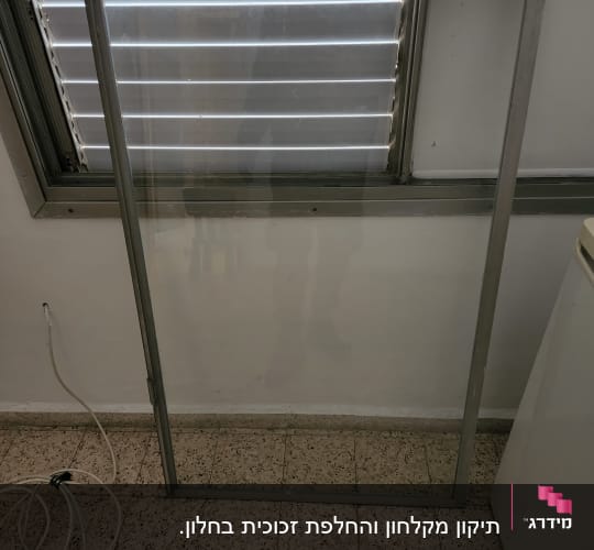 זכוכית במסגרת מתכת על רצפה מרוצפת